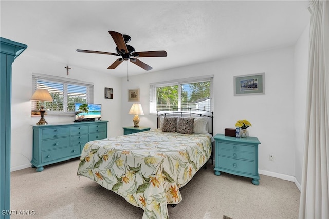 carpeted bedroom with ceiling fan and multiple windows