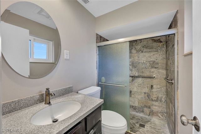 bathroom featuring vanity, toilet, and a shower with door