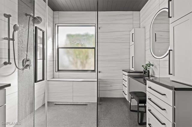 bathroom featuring a tile shower and vanity