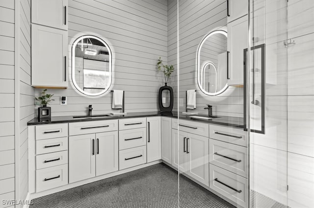 bathroom featuring tile patterned flooring, vanity, decorative backsplash, and a shower with door