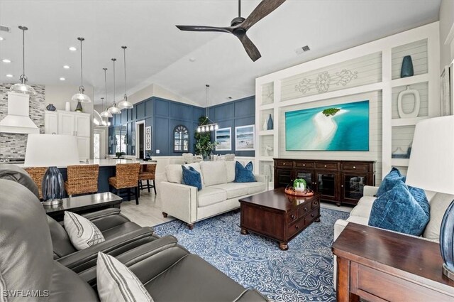 living room featuring ceiling fan and vaulted ceiling