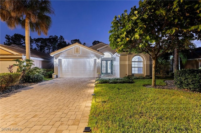 view of front of house featuring a yard and a garage