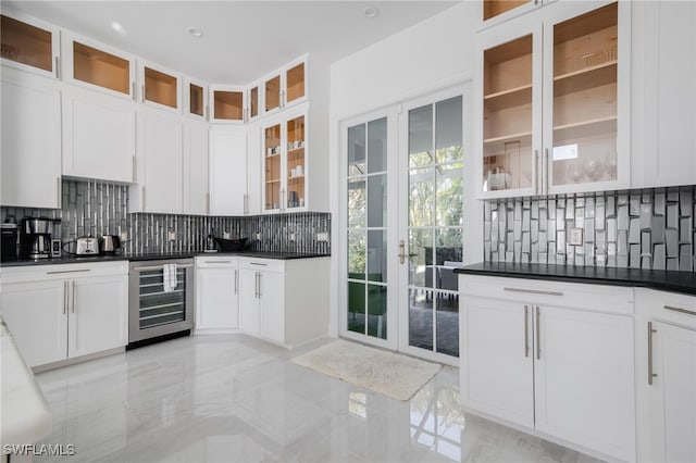 kitchen featuring wine cooler, white cabinetry, and tasteful backsplash