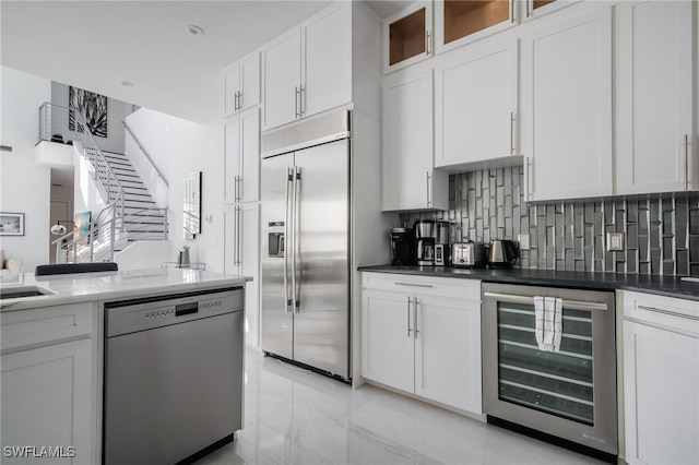 kitchen with white cabinetry, wine cooler, dishwashing machine, and built in refrigerator