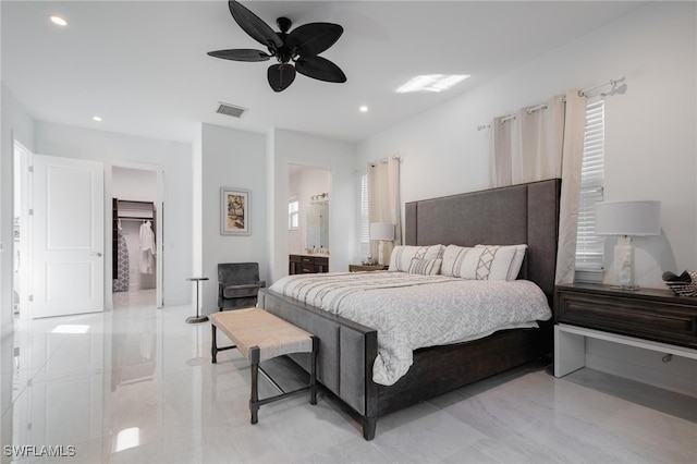 bedroom featuring a walk in closet, connected bathroom, and ceiling fan