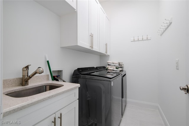 washroom with sink, separate washer and dryer, and cabinets