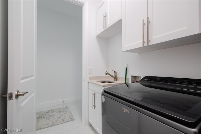 clothes washing area with washer / dryer, sink, and cabinets