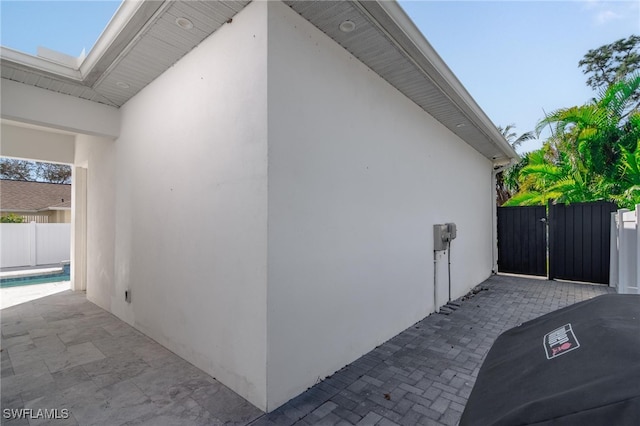 view of side of property featuring a pool and a patio