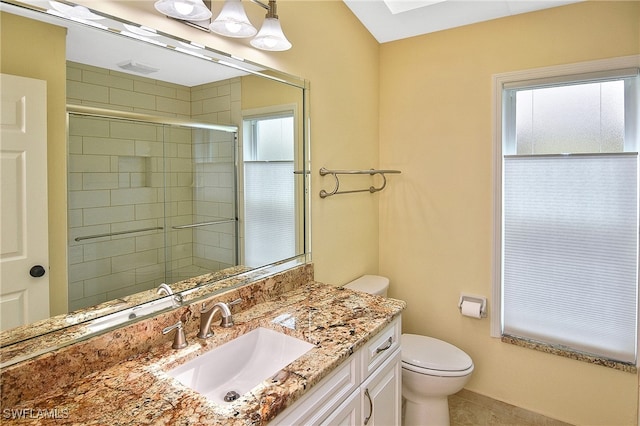 bathroom with tile patterned flooring, vanity, toilet, and a shower with shower door