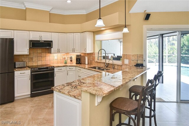 9812 Fathom Ct, Fort Myers, FL 33919 - kitchen featuring electric range, freestanding refrigerator, a sink, a peninsula, and white cabinetry