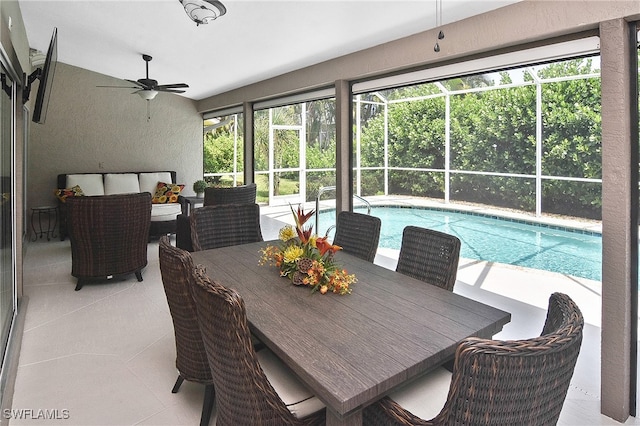 sunroom / solarium with ceiling fan and a swimming pool