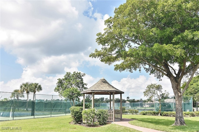 view of property's community with tennis court, a yard, and a gazebo