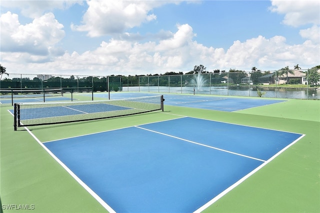 view of tennis court with a water view