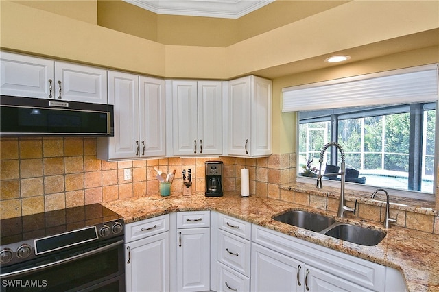 kitchen with stainless steel electric stove, white cabinetry, sink, and ornamental molding