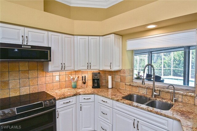 9812 Fathom Ct, Fort Myers, FL 33919 - kitchen with a sink, range with electric cooktop, black microwave, crown molding, and white cabinets