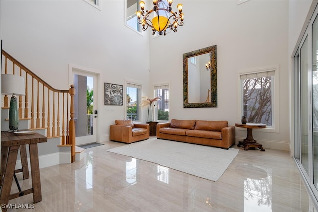 interior space with a notable chandelier, a towering ceiling, and plenty of natural light