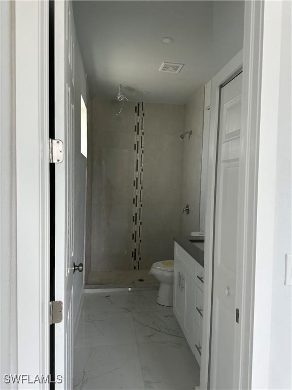 bathroom with a shower, vanity, and toilet