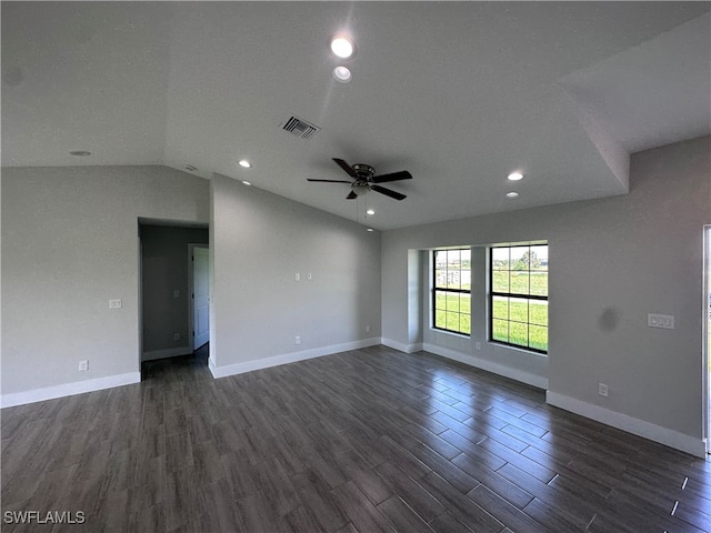 spare room featuring dark wood-type flooring, vaulted ceiling, and ceiling fan