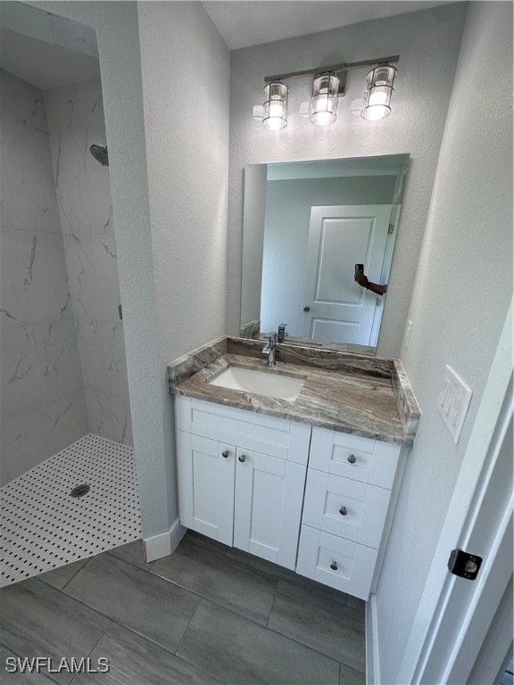 bathroom with vanity and tiled shower