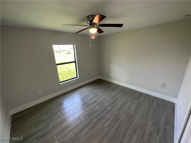 spare room featuring dark wood-type flooring and ceiling fan