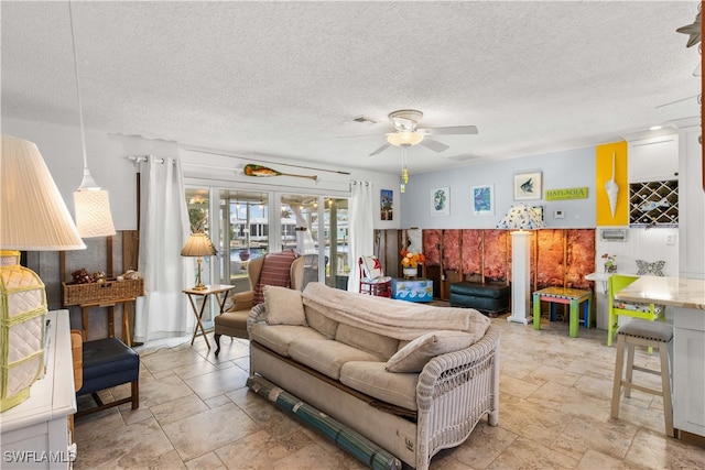 living room featuring french doors, a textured ceiling, and ceiling fan