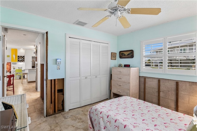 bedroom featuring ceiling fan, a textured ceiling, and a closet