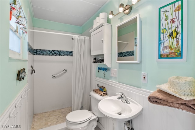 bathroom featuring curtained shower, toilet, and sink