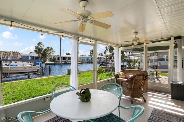 sunroom / solarium featuring ceiling fan and a water view