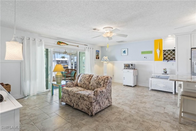 living room featuring a textured ceiling, visible vents, and a ceiling fan