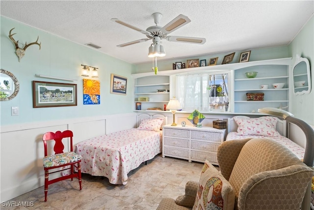 bedroom featuring a textured ceiling, ceiling fan, and visible vents