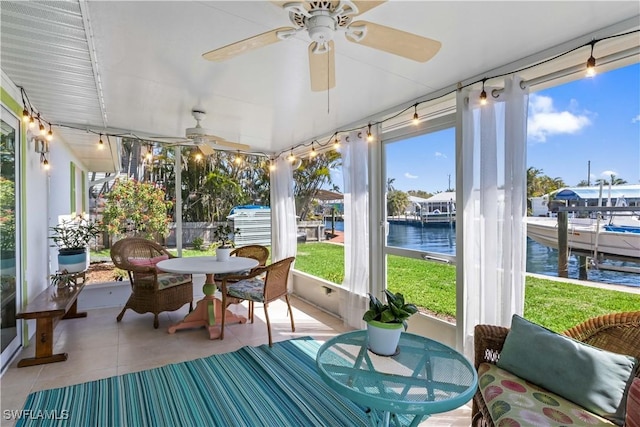 sunroom with a water view and a ceiling fan