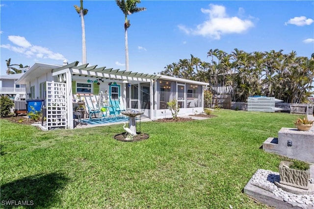 rear view of house featuring a lawn, fence, a sunroom, and a pergola