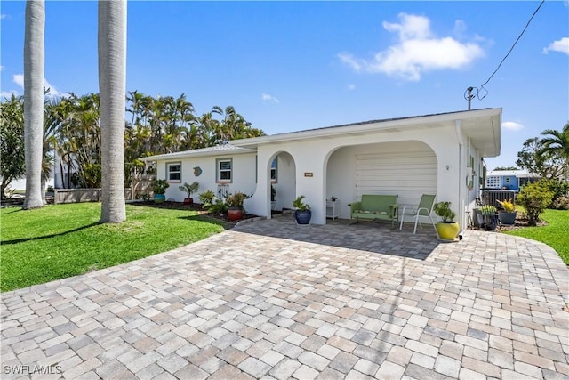 ranch-style house with a front yard and stucco siding