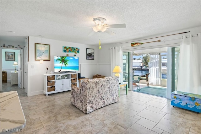 living area featuring a textured ceiling and a ceiling fan