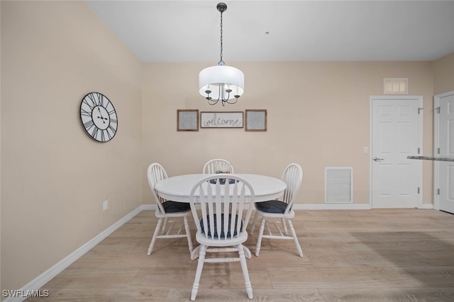 dining space featuring a chandelier and light hardwood / wood-style flooring