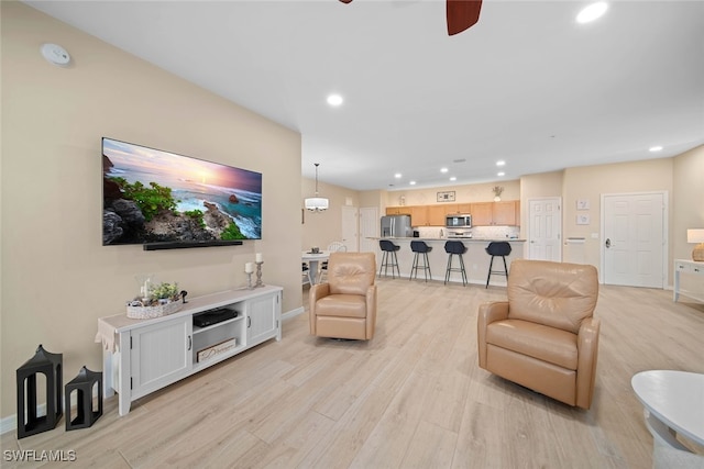 living room with light wood-type flooring and ceiling fan