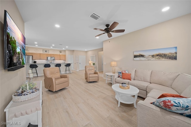 living room with light hardwood / wood-style floors and ceiling fan