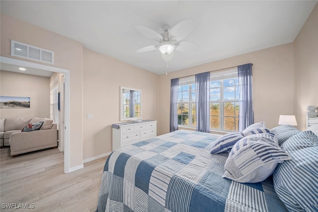 bedroom with multiple windows, light wood-type flooring, and ceiling fan