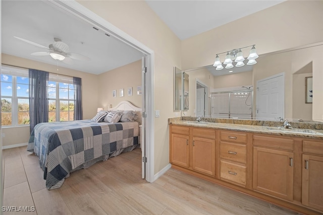 bedroom featuring ceiling fan, sink, and light wood-type flooring