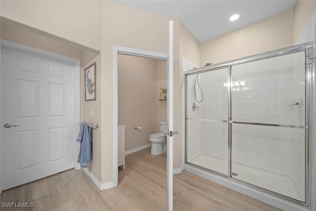 bathroom with hardwood / wood-style floors, toilet, and walk in shower