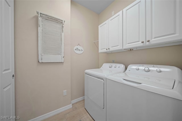 washroom featuring light hardwood / wood-style flooring, washer and dryer, and cabinets