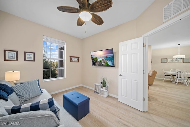 living area with light wood-type flooring and ceiling fan