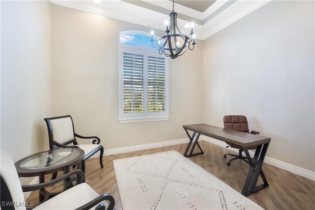 office featuring crown molding, a tray ceiling, hardwood / wood-style floors, and a notable chandelier