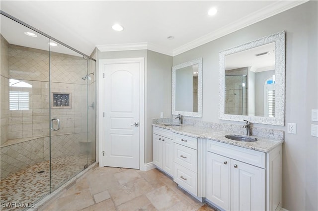 full bathroom with double vanity, a stall shower, ornamental molding, and a sink