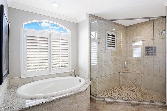 bathroom featuring a shower stall, a garden tub, and crown molding