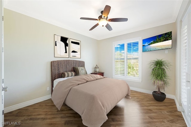 bedroom with dark wood-type flooring, ceiling fan, and crown molding