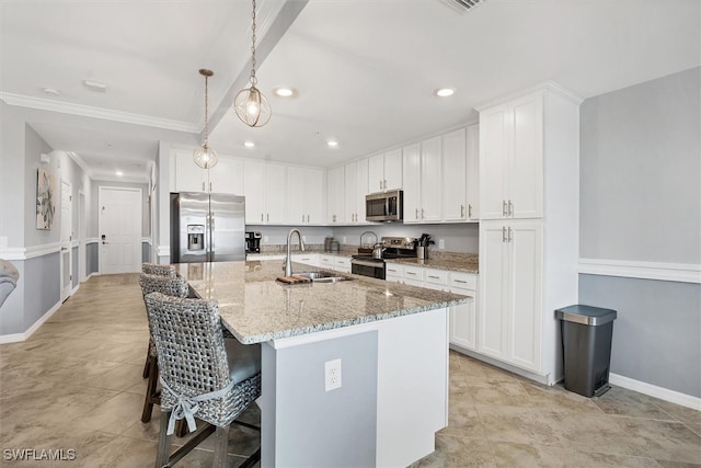 kitchen featuring light stone counters, a center island with sink, stainless steel appliances, sink, and white cabinets