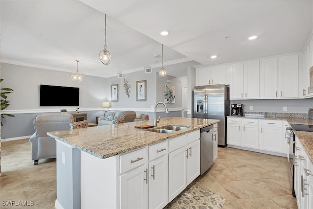 kitchen with stainless steel appliances, white cabinets, sink, an island with sink, and ornamental molding