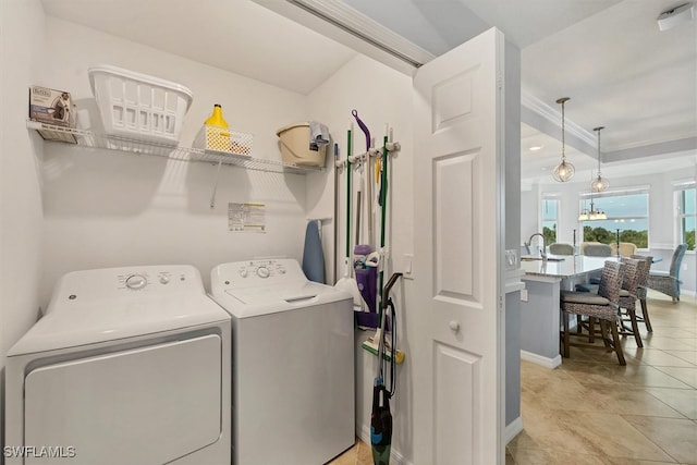 clothes washing area featuring light tile patterned floors, washing machine and dryer, and sink