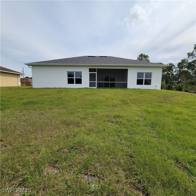 rear view of house featuring a lawn